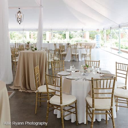 Reception tables and chairs beneath the tent at Clark Gardens